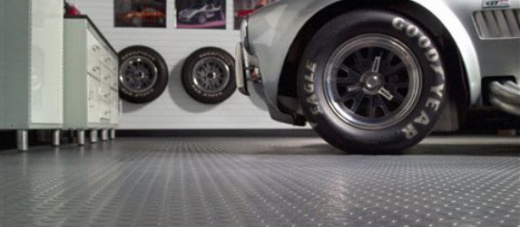 A car rests on industrial grade flooring.